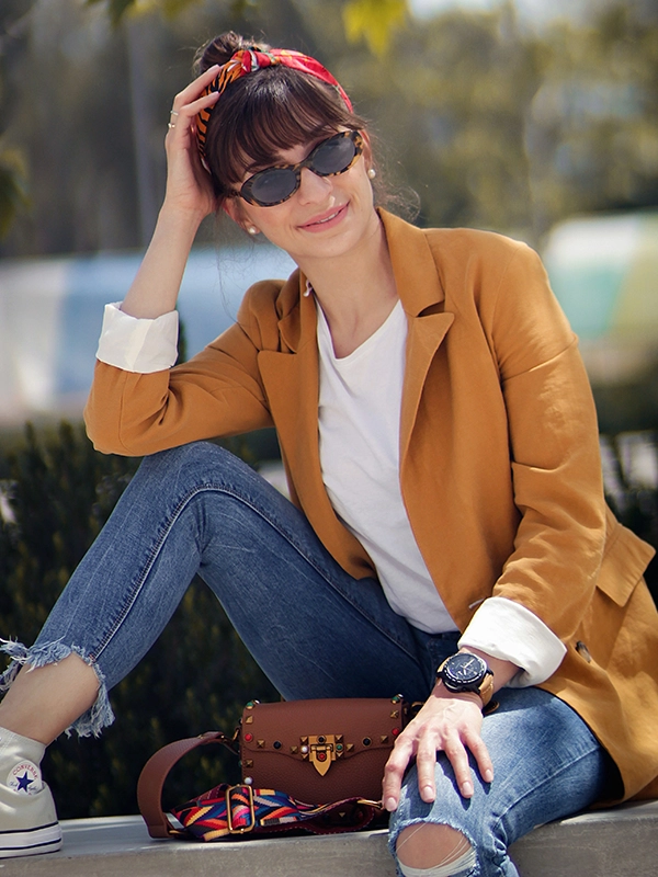 woman sitting on concrete with a full consignment outfit